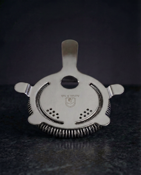 Hawthorne Strainer in stainless steel, four-prong design with a coiled spring and the Aurum & Ash logo etched on the face.