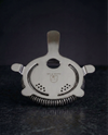 Hawthorne Strainer with coiled spring and four-prong design, included in The Full Bar.