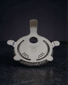 Hawthorne Strainer with coiled spring and four-prong design, included in The Stirred Set.